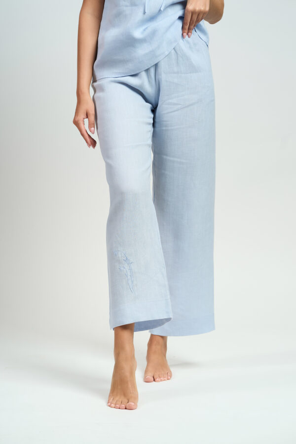 Zbliżenie na błękitne lniane spodnie piżamowe z delikatnym haftem na nogawce